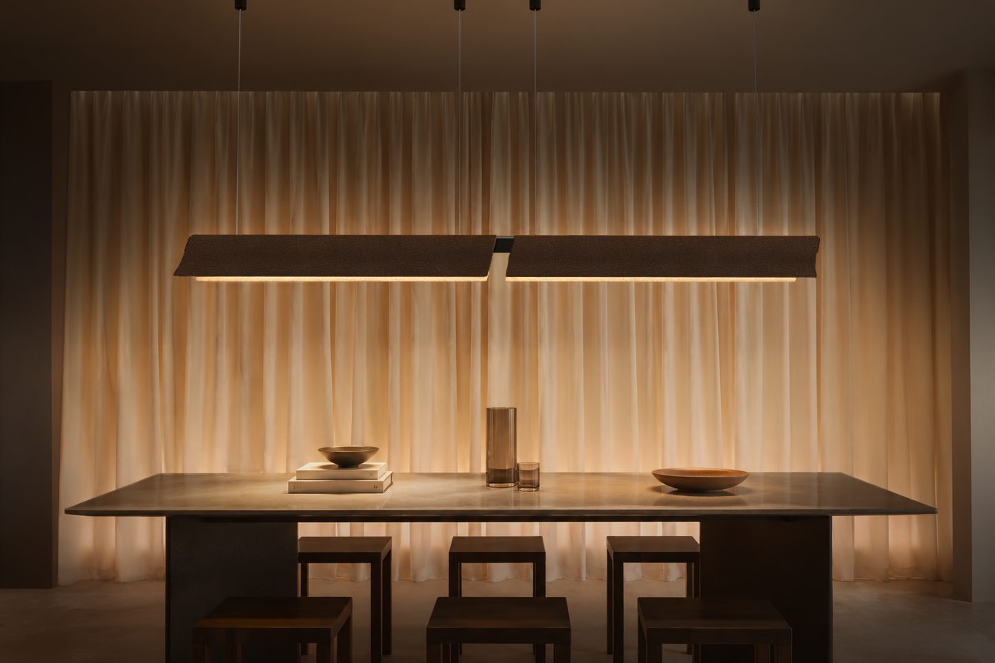 Dual Flow acoustic pendant lights suspended above a dining table with integrated LED illumination and recycled PET felt construction.