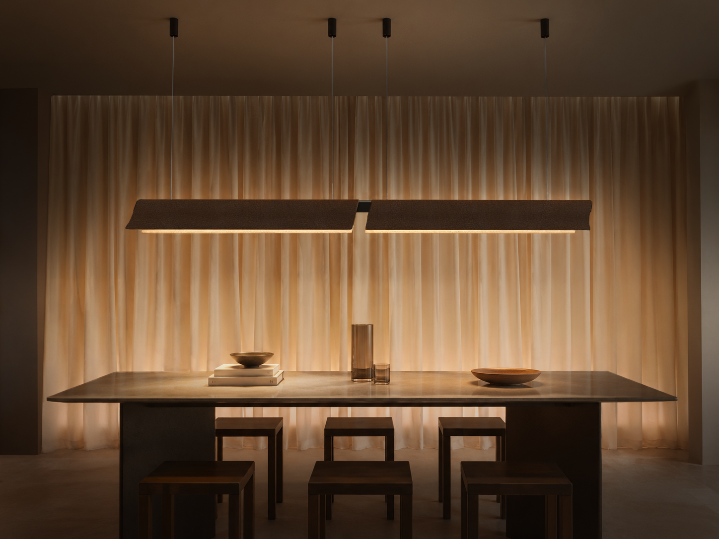 Dual Flow acoustic pendant lights suspended above a dining table with integrated LED illumination and recycled PET felt construction.