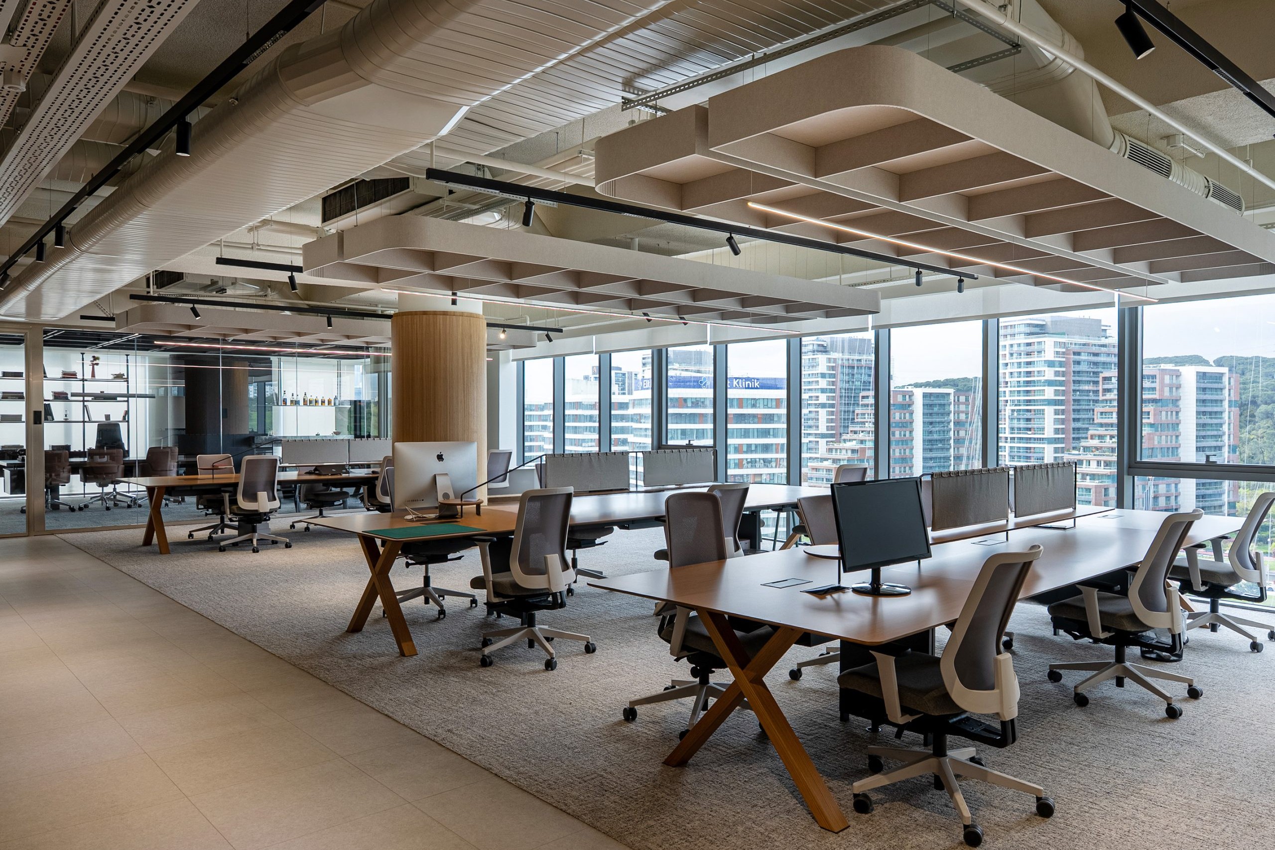 Custom Flat Cloud acoustic ceiling panels suspended above workstations in the Konyalı Saat office.