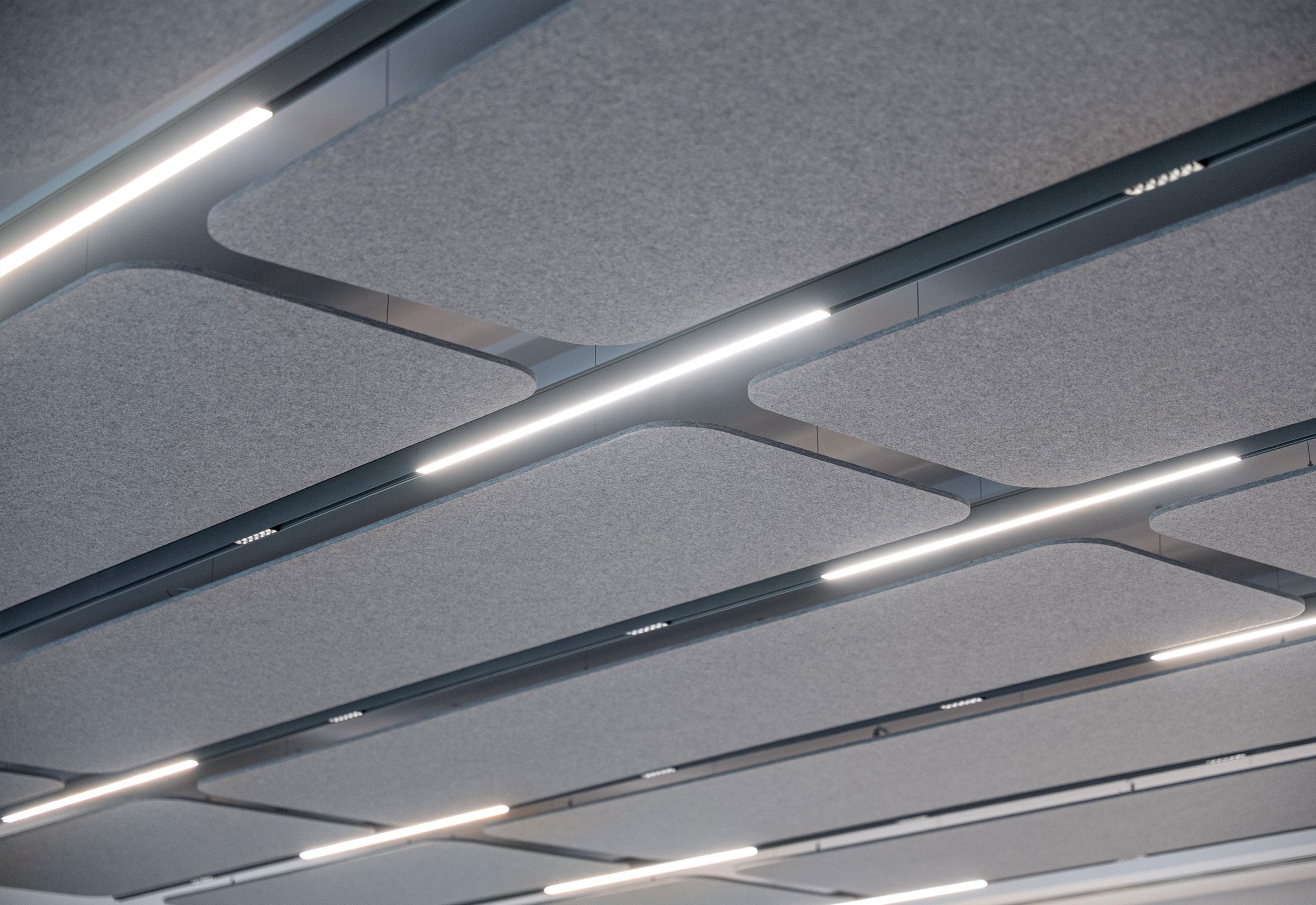 Flat Cloud acoustic ceiling panels with linear lighting at Nobel